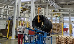 The overhead crane is used to lift plastic rolls onto the machine
