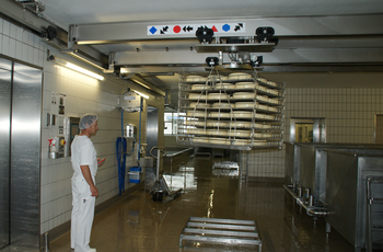 Overhead travelling crane with intermediate structure in cheese production