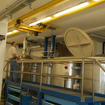 Crane system lifts metal container out of basin