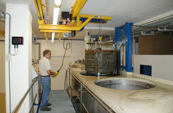Crane system lifts metal container out of basin