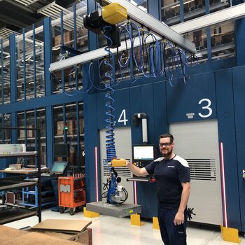 Transport of blanks to loading station by means of crane system