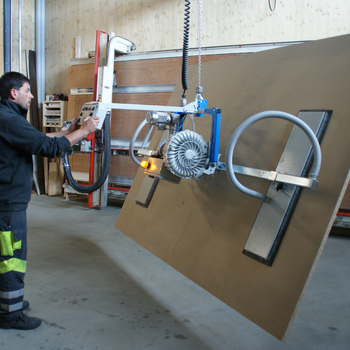 A large wooden panel is lifted by the forklift, tilted by 90° and moved to the vertical saw for cutting to size