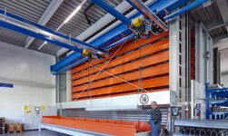 GISKB crane with parallel crane bridges lifts long, bulky metal pieces