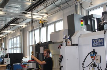 Light crane system with electric chain hoist for equipping machines