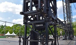 Stage construction with electric chain hoists at an outdoor music event 