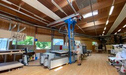 The crane system is used to transport wooden panels from the rack to the machine