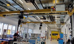 Machine components are lifted onto the workbench with the travelling crane