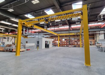 Freestanding system with travelling crane A free-standing system provides for the overhead transport of goods